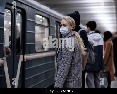 Mosca. Russia. 28 settembre 2020 UNA giovane donna che indossa una maschera medica protettiva si trova sulla piattaforma di una stazione della metropolitana, in attesa di salire a bordo Foto Stock