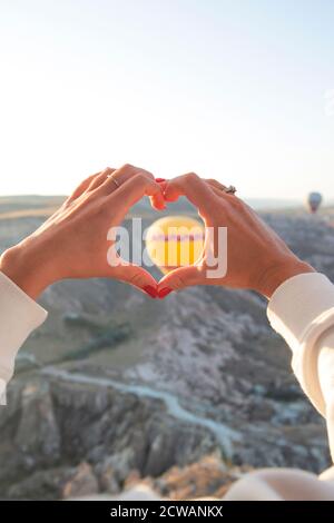 Palloncini volanti nel cielo e mani femminili che raggiungono per loro Foto Stock