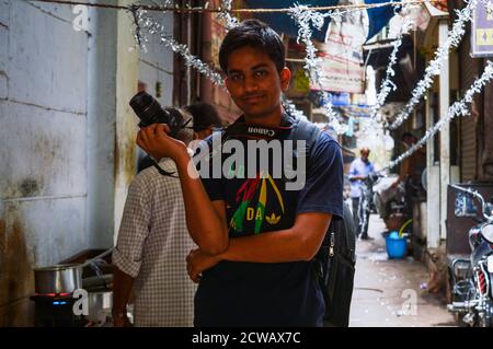 Un ritratto di fotografo che sta coprendo chandani chowk, vecchia delhi, india Foto Stock