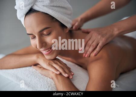 Massaggiatrice professionale che massaggiano la schiena femminile nel centro benessere Foto Stock