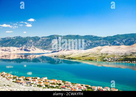 Croazia, costa adriatica, città di Pag sull'isola di Pag e Velebit montagna sullo sfondo Foto Stock