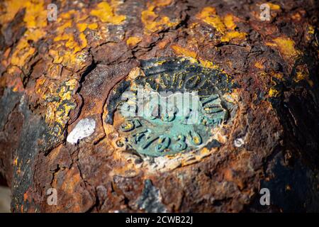 Macro fotografia di un vecchio posto arrugginito ormeggio sul lungomare in un piccolo porticciolo, elemento per ormeggiare le navi nel porto, sicurezza Foto Stock
