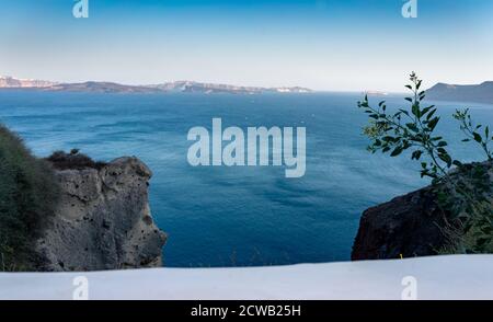 Splendida vista panoramica da Oia alla caldera e al vulcano in una giornata di sole. Pittoresco sfondo naturale con spazio per la copia del testo. Isola di Santorini, Cy Foto Stock