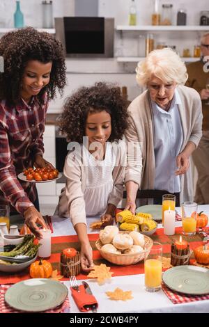 Focalizzazione selettiva delle donne multietniche e delle donne afro-americane che servono cena di ringraziamento Foto Stock