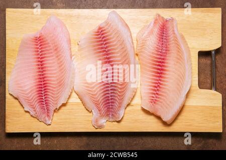Primo piano di filetto fresco crudo di pesce tilapia, colpo d'asta Foto Stock