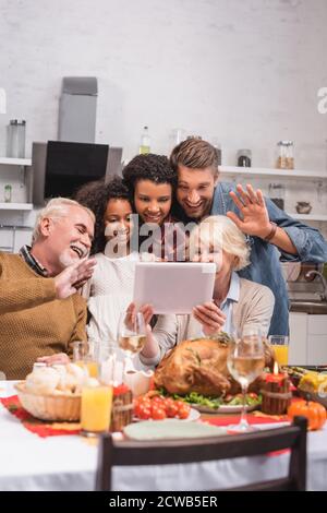 Fuoco selettivo della famiglia multietnica che ha videochiamata su digitale tablet durante la celebrazione del ringraziamento Foto Stock