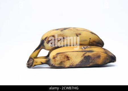 Banana matura con macchie nere sulla pelle. Vecchia banana isolato su sfondo bianco Foto Stock