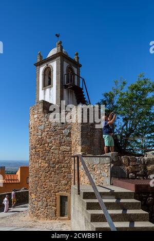 Figueira de Castelo Rodrigo, Portogallo - 08 23 2020: Vista a un turista scattare una foto con il suo telefono, all'interno medievale fortezza villaggio torre e m Foto Stock