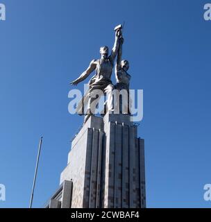 Operaio e la scultura di Kolkhoz Donna a Mosca, raffigura due figure con una falce e un martello sollevati sulla testa. E' alta 24.5 metri (78 piedi), realizzata in acciaio inossidabile da vera Mukhina per la Fiera Mondiale del 1937 a Parigi e successivamente trasferita a Mosca. La scultura è un esempio dello stile realistico socialista, così come dello stile Art Deco. L'operaio tiene in mano un martello e la donna del kolkhoz una falce per formare il simbolo del martello e della falce. Foto Stock