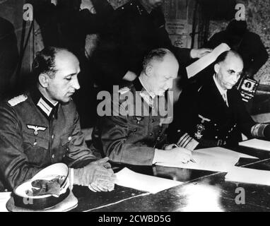 Resa della Germania nazista, Reims, Francia, 7 maggio 1945. Il generale Alfred Jodl, capo di stato maggiore tedesco, firma il documento che conferma la resa incondizionata della Germania agli Alleati. Al suo fianco si trovano il suo maggiore aiutante Wilhelm Oxenius (a sinistra) e l'ammiraglio Hans Georg von Friedeburg, comandante della Marina tedesca. Il fotografo è sconosciuto. Foto Stock