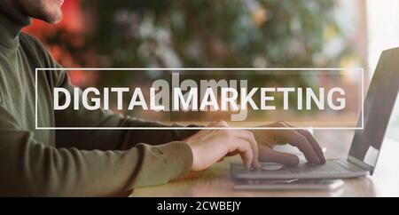 Uomo d'affari che utilizza il computer portatile che promuove il contenuto Web seduto al caffè Foto Stock