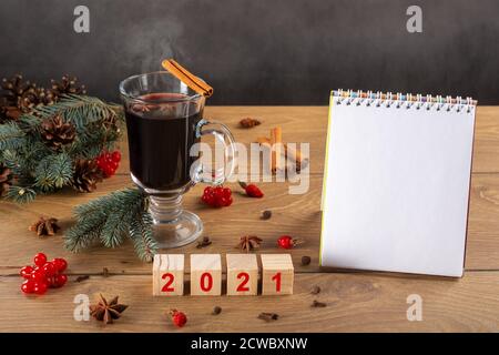 Caldo VIN brulé, albero di Natale, decorazione, coni, da fare lista. 2021 su cubetti di legno, taccuino vuoto. Piani di scrittura per il nuovo anno. Pianificazione Foto Stock