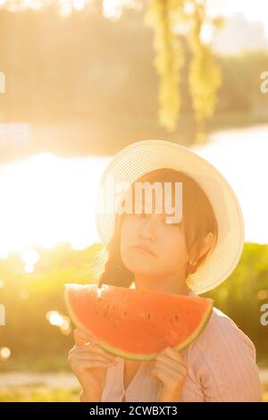 Tenendo anguria giovane donna Foto Stock