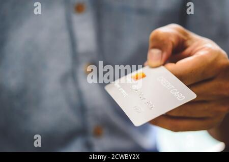 Mano dell'uomo che tiene le carte di credito. Shopping in linea dall'applicazione di prestito della carta di credito. Foto Stock