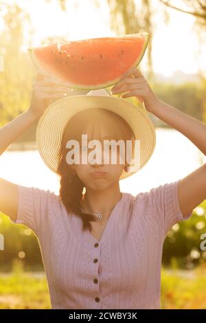Tenendo anguria giovane donna Foto Stock