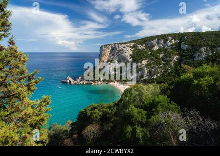 spiaggia soleggiata con acqua cristallina e famosa formazione rocciosa. Spiaggia Cala Luna, Sardegna, Italia Foto Stock