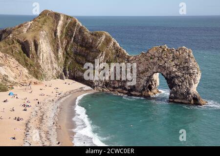 Durdle Door o Dor scogliere e arco di mare di roccia. Parte della tenuta di Lulworth sulla costa jurassica del Dorset. Con persone in spiaggia. Foto Stock