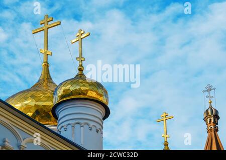 Cupole dorate e croci della Chiesa ortodossa contro a. primo piano cielo blu Foto Stock