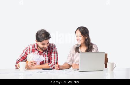 Focalizzato giovane coppia indiana contabilità, il calcolo delle fatture, discutere di bilancio di pianificazione insieme utilizzando online servizi bancari e calcolatrice, il controllo Foto Stock