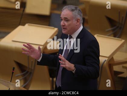 Ministro per l'istruzione superiore, l'istruzione superiore e la scienza, Richard Lochhead MSP durante le interrogazioni d'attualità al Parlamento scozzese a Holyrood, Edimburgo. Foto Stock