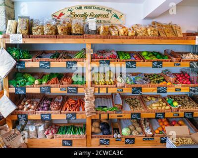 FARM SHOP LOCALE UK PRODUCE BLACKBOARD ETICHETTE PREZZI prodotti tradizionali di strada alta fattoria interni negozio con frutta fresca locale e verdure in vendita in kilos lavagne. Il cartello riporta ‘tutte le verdure di provenienza locale’ Stow on the Wold Cotswolds UK Foto Stock