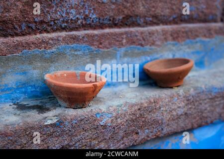 Lampada olio Pooja Diya lampada sulla parete blu della casa a Jodhpur, Rajasthan, India Foto Stock