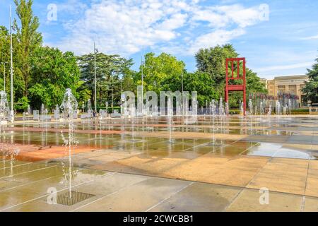 Ginevra, Svizzera - 16 agosto 2020: Place des Nations con fontane e sedia rotta scultura di fronte al Palazzo delle Nazioni Unite a Ginevra, principale Foto Stock