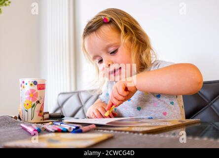 Giovane ragazza di 3 anni facendo arti e mestieri a. apprendimento a casa Foto Stock