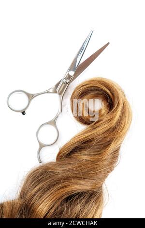 Forbici professionali e una ciocca di capelli biondi isolati su sfondo bianco. Foto Stock