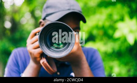 Fotografo africano uomo che prende una fotocamera.16:9 stile Foto Stock