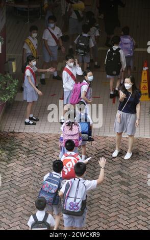 Hong Kong, Cina. 29 Settembre 2020. Gli studenti si accodano per entrare in una scuola elementare a Hong Kong, Cina meridionale, 29 settembre 2020. L'epidemia si è notevolmente attenuata a Hong Kong a seguito di una rapida risposta antiepidemica e di un forte sostegno da parte delle autorità centrali. Le misure di allontanamento sociale sono state in parte rilassate e la vita della gente ha cominciato a ritornare alla normalità. Tutti gli studenti sono tornati ai campus martedì in due fasi dopo che l'apprendimento in persona è diventato disponibile circa una settimana fa per alcuni gradi. Credit: Wang Shen/Xinhua/Alamy Live News Foto Stock