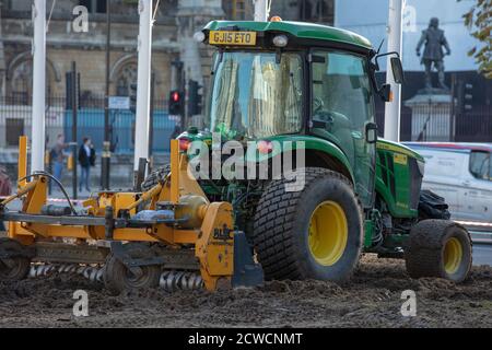 Trattore visto essere utilizzato da un'azienda di architettura paesaggistica quando si posa un nuovo prato sul giardino di Parliament Square. Foto Stock