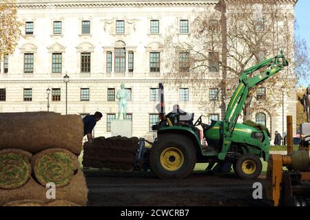 Paesaggisti visto al lavoro con macchinari pesanti e la posa di un nuovo prato sul giardino di Parliament Square. Foto Stock