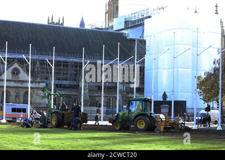 Paesaggisti visto al lavoro con macchinari pesanti e la posa di un nuovo prato sul giardino di Parliament Square. Foto Stock