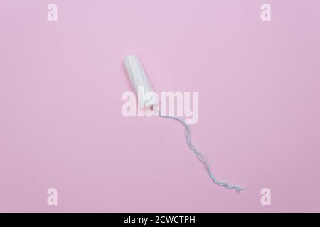 Tampon bianco igiene le giornate mestruali delle donne. Pulire il tampone assorbente in cotone su sfondo rosa. Foto Stock