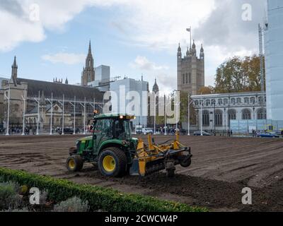 Trattore visto essere utilizzato da un'azienda di architettura paesaggistica quando si posa un nuovo prato sul giardino di Parliament Square. Foto Stock