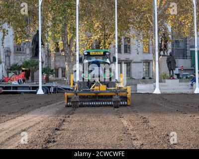 Trattore visto essere utilizzato da un'azienda di architettura paesaggistica quando si posa un nuovo prato sul giardino di Parliament Square. Foto Stock