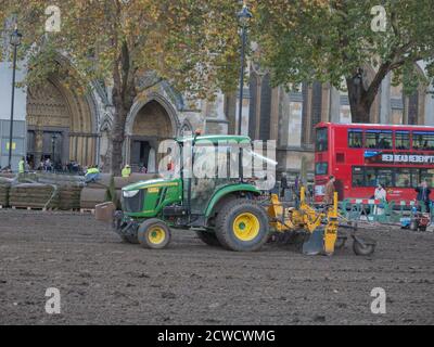 Trattore visto essere utilizzato da un'azienda di architettura paesaggistica quando si posa un nuovo prato sul giardino di Parliament Square. Foto Stock