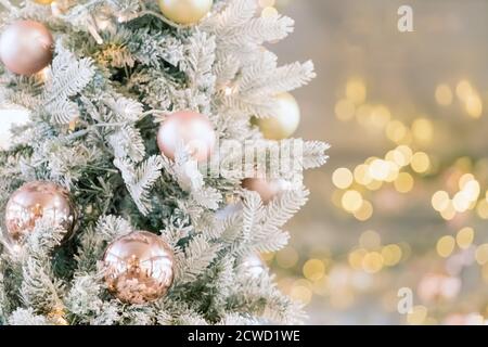 Albero di natale decorato in oro con palline e luci su sfondo sfocato. Buon Natale card. Spazio di copia. Natale sfondo festivo. Foto Stock