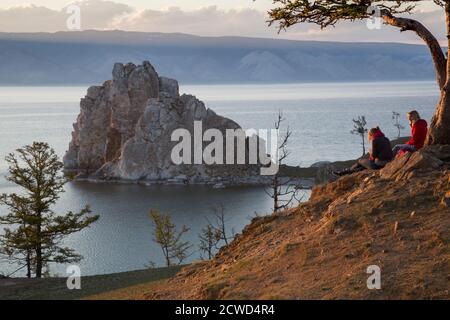 I turisti osservare la costa del lago Baikal, lo sciamano rock, la struttura ad albero dei desideri e cape Burhan sull'isola di Olkhon in Russia Foto Stock