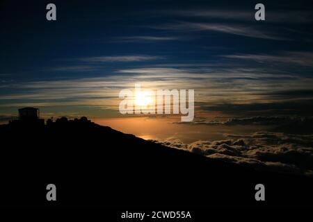 Il tramonto a Maui è diverso ogni volta, visto qui alle 10,023' 'Città della Scienza' nelle fasi successive appena prima e dopo il tramonto passa sotto l'orizzonte. Foto Stock