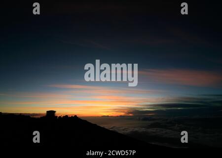 Il tramonto a Maui è diverso ogni volta, visto qui alle 10,023' 'Città della Scienza' nelle fasi successive appena prima e dopo il tramonto passa sotto l'orizzonte. Foto Stock