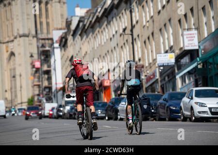 Due pendolari maschi in bicicletta su Park Street a Bristol. Foto Stock
