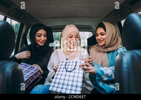 Tre amiche uscenti a Dubai. Ragazze che indossano l'abaya tradizionale degli emirati arabi uniti Foto Stock