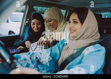 Tre amiche uscenti a Dubai. Ragazze che indossano l'abaya tradizionale degli emirati arabi uniti Foto Stock