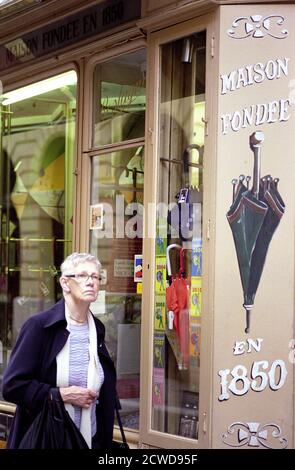 DONNA CHE PASSA DA UN NEGOZIO DI OMBRELLI VINTAGE NEL VECCHIO NIZZA CITTÀ - COSTA AZZURRA - FOTOGRAFIA DI STRADA - COLORE FILM D'ARGENTO © FREDERIC BEAUMONT Foto Stock