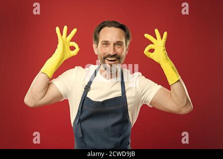 Pulizia eccellente. Ragazzo con bearded che pulisce a casa. Lavoratore con bearded. A protezione della pulizia. Servizio di pulizia e servizio domestico. Molto lavoro. Uomo in grembiule con guanti per la pulizia. Giorno di pulizia oggi. Foto Stock