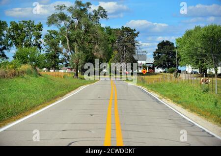 South Elgin, Illinois, Stati Uniti. Una strada di campagna in non così diritto una linea passa attraverso pascoli e praterie. Foto Stock