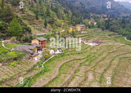 (200929) -- SHIZHU, 29 settembre 2020 (Xinhua) -- Foto aerea scattata l'8 aprile 2020 mostra le case residenziali rinnovate fra i campi agricoli nel villaggio di Huaxi della cittadina di Zhongyi, Contea Autonoma di Shizhu Tujia, nel sud-ovest del comune di Chongqing della Cina. Il comune di Zhongyi a Chongqing ha avuto un'elevata incidenza di povertà a causa della scarsa qualità del suolo e dei trasporti sconvenienti in un terreno montuoso. Prima del 2018, più del 60% della forza lavoro nel villaggio di Huaxi uscì in altre città per guadagnarsi da vivere, lasciando quasi il 60% dei terreni agricoli incolti. Ma gli sforzi per alleviare la povertà b Foto Stock