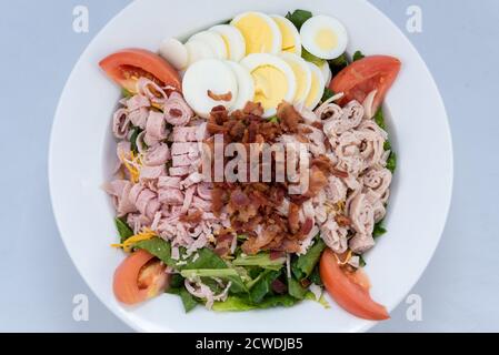 Vista dall'alto di un abbondante pasto che serve una ricca insalata per la colazione, con farciture in un grande recipiente. Foto Stock